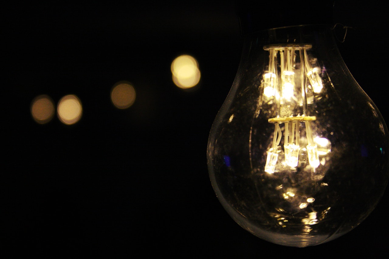 Close up of a lit light bulb in a dark room