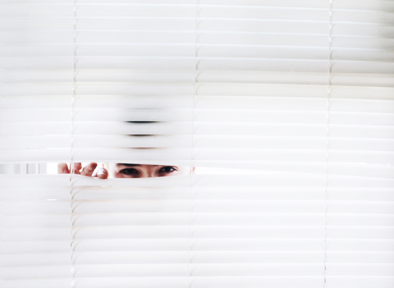 Spying through blinds representing how Four Corner Analysis looks at competitor strategy