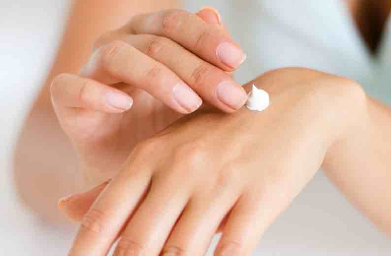 Applying cream to the back of a hand